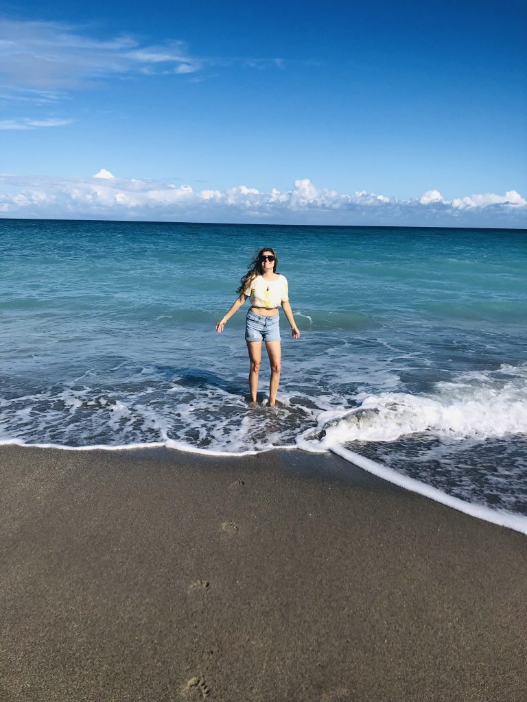 Girl in the ocean smiling bravely after publishing poetry book